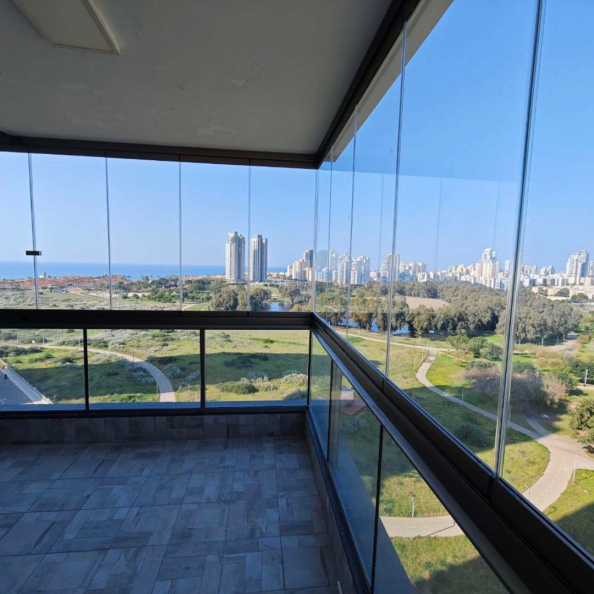 זיגוג מרפסת בקומה ה־22 בנתניה עם נוף לים